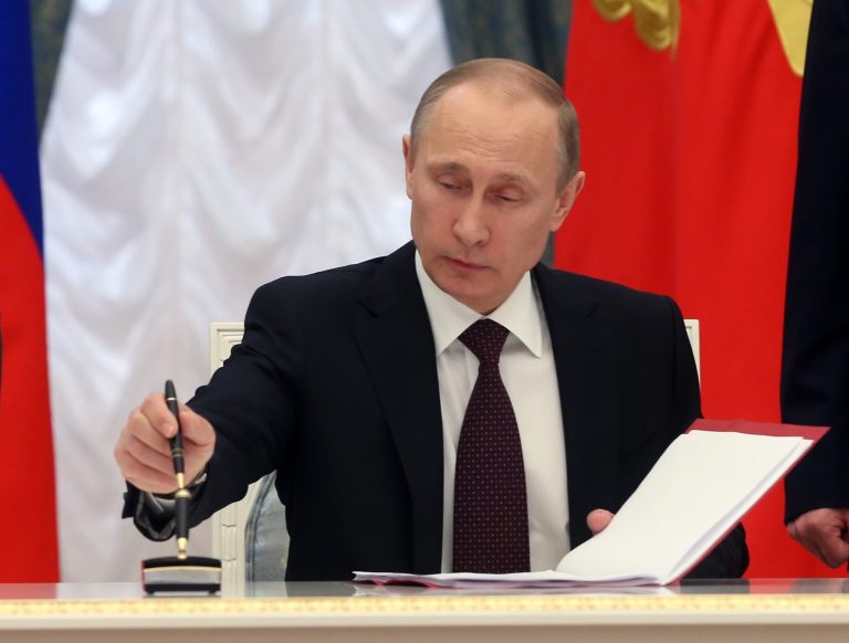 Russian President Vladimir Putin signs bills making Crimea part of Russia, in the Kremlin in Moscow on Friday. (AP Photo/Sergei Chirikov, Pool)