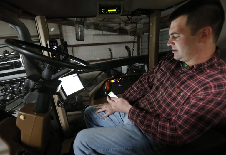 Nick Guetterman looks over the data shared by his crop sprayer and cell phone while on his farm near Bucyrus, Kan., on Feb. 19. (AP Photo/Orlin Wagner)