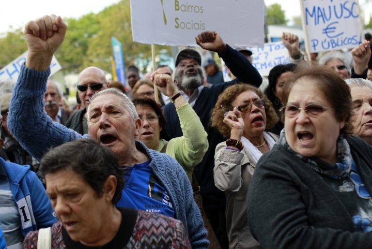 In this picture shot April 22 2014, people protest rent hikes and evictions in social housing neighborhoods in Lisbon. Budget cuts have forced the closure of local health centers and reduced subsidies for prescription drugs. High schools have seen staff levels fall and the purchase of new equipment postponed. New laws have made it easier and cheaper to hire and fire workers. And the scrapping of rent controls has left many in danger of losing their homes. (AP Photo/Francisco Seco)