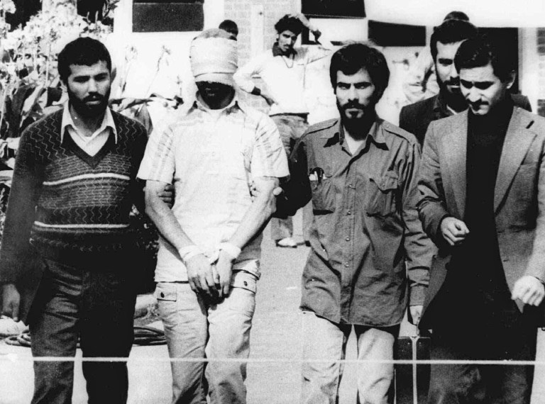 One of the hostages being held at the U.S. Embassy in Tehran is displayed to the crowd, blindfolded and with his hands bound, outside the embassy. Fifty-two of the hostages endured 444 days of captivity. Former Iranian hostages had varied reactions to the news of the nuclear deal between the U.S. and Iran in what is being billed as a trust-building agreement designed to yield a more comprehensive deal six months from now. (AP Photo/File)