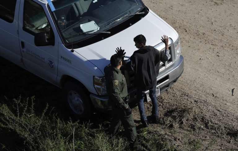 In this Wednesday, Nov. 16, 2016, photo, a U.S. Customs and Border Patrol agent works with a suspected immigrant entering the country illegally along the Rio Grande in Hidalgo, Texas. (AP Photo/Eric Gay)