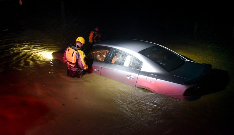 Rescue staff from the Municipal Emergency Management Agency investigate an empty flooded car during the passage of Hurricane Irma through the northeastern part of the island in Fajardo, Puerto Rico, on Wednesday. The storm is expected to make landfall in Florida later this week. (AP Photo/Carlos Giusti)