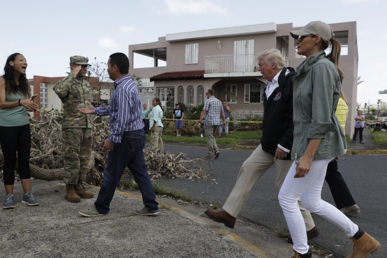 President Donald Trump and first lady Melania Trump take a walking tour to survey hurricane damage and recovery efforts in a neighborhood in Guaynabo, Puerto Rico, Tuesday, Oct. 3, 2017. (AP Photo/Evan Vucci)