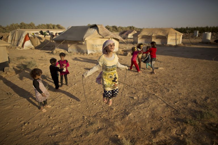 Syrian refugee girl Zubaida Faisal, 10, skips a rope while she and other children play near their tents at an informal tented settlement near the Syrian border on the outskirts of Mafraq, Jordan. (AP Photo/Muhammed Muheisen, file)
