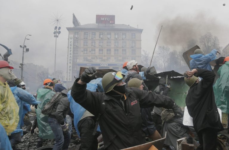 Anti-government protesters throw stones during clashes with riot police in Kiev's Independence Square, the epicenter of the country's current unrest, Kiev, Ukraine, Wednesday, Feb. 19, 2014. (AP Photo/Efrem Lukatsky)
