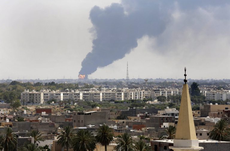 Black smoke billows over the skyline as a fire at the oil depot for the airport rages out of control after being struck in the crossfire of warring militias battling for control of the airfield, in Tripoli, Libya Monday, July 28, 2014. The latest violence to plague the country has so far killed scores of people and wounded hundreds as foreigners flee the chaos. Libya's interim government said in a statement that the fire could trigger a 