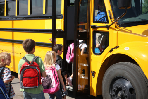 Elementary school students get on bus