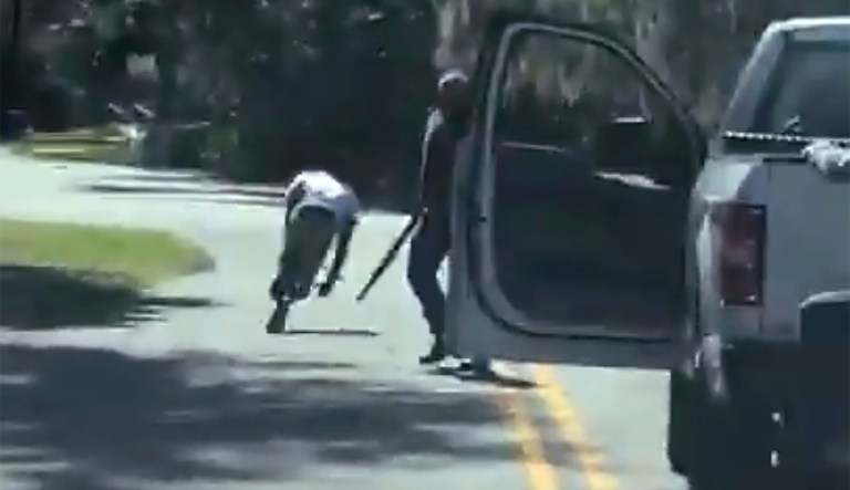 This image from a video posted on Twitter on May 5, 2020, purports to show Ahmaud Arbery stumbling and falling to the ground after being shot as Travis McMichael stands by holding a shotgun in a neighborhood outside Brunswick, Georgia, on Feb. 23, 2020. The AP has not been able to verify the source of the video.