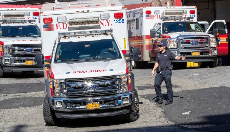 A patient wears a protective face mask as she is loaded into an ambulance at The Brooklyn Hospital Center emergency room, Wednesday, March 18, 2020, in New York. Anticipating a spike in coronavirus patients, New York City-area hospitals are clearing out beds, setting up new spaces to triage patients and urging people with mild symptoms to consult health professionals by phone or video chat instead of flooding emergency rooms that could be overrun.
