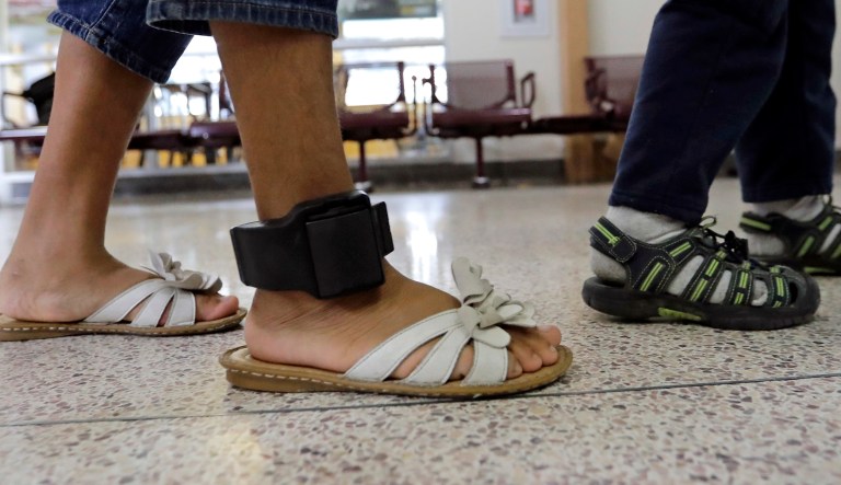 An immigrant woman wears an ankle monitor as she walks through the central bus station after being processed and released by U.S. Customs and Border Protection, Sunday, June 24, 2018, in McAllen, Texas.