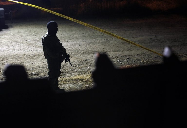 A U.S. Border Patrol officer stands guard near a drain hole, used as an illegal entrance to U.S., in the Mexican side of the U.S.-Mexico border in Tijuana, Mexico, late Monday, June 29, 2009.