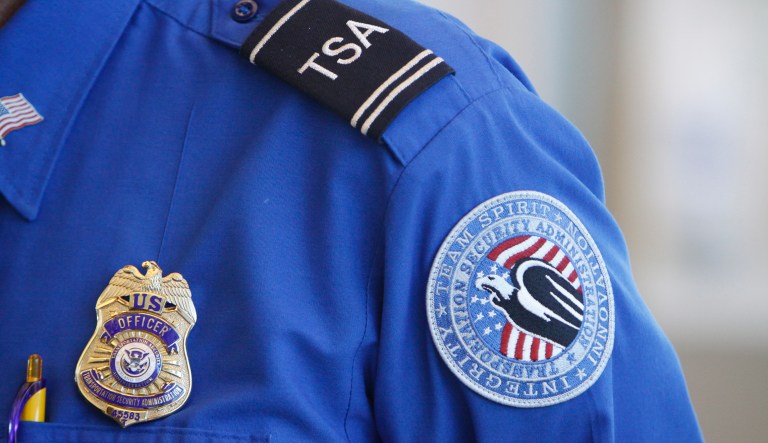 The badge and TSA logo patch are seen on the uniform of a Transportation Security Administration employee.