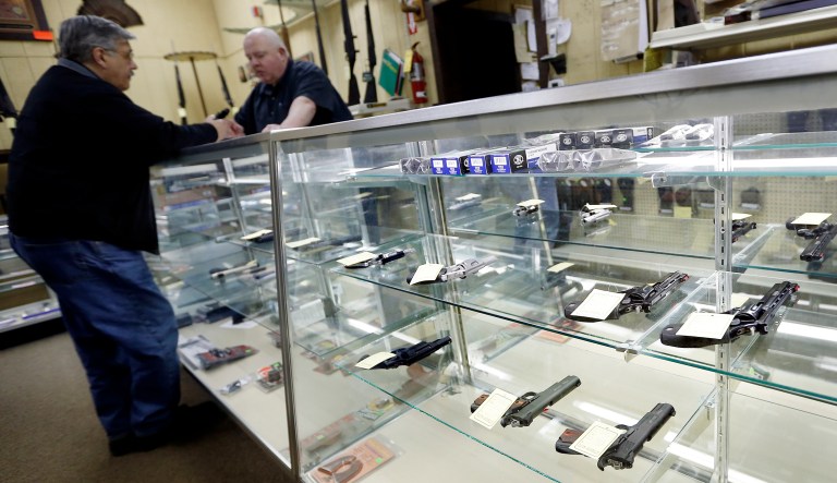 Gun World salesman Alfred Ozga, right, talks with a customer at the sparse display of handguns available at the store on Wednesday, Jan. 16, 2013 in Harrisville, Pa. President Barack Obama urged Congress Wednesday to require background checks for all gun sales and ban military-style weapons and high-capacity ammunition magazines, contentious measures aimed at curbing gun violence in America. Ozga said he didn't think the ban on assault guns would work and that although the idea of a universal background check appears to be a good idea, he would not support it, seeing that as another infringement on constitutional rights. 