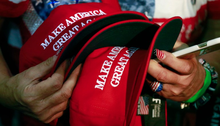 In this June 2, 2016, file photo, a woman holds hats to get them autographed by Republican presidential candidate Donald Trump during a rally in San Jose, Calif.
