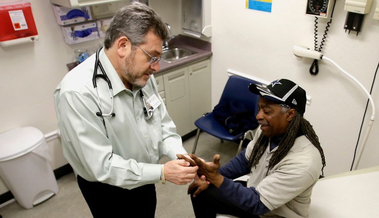 Dr. Leonid Basovich, left, examines Michael Epps at a clinic.