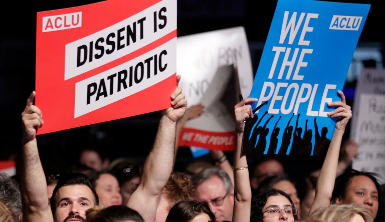 A group of people hold up signs during a meeting called "The Resistance Training" hosted by the American Civil Liberties Union on March 11, 2017 in Coral Gables, Fla.