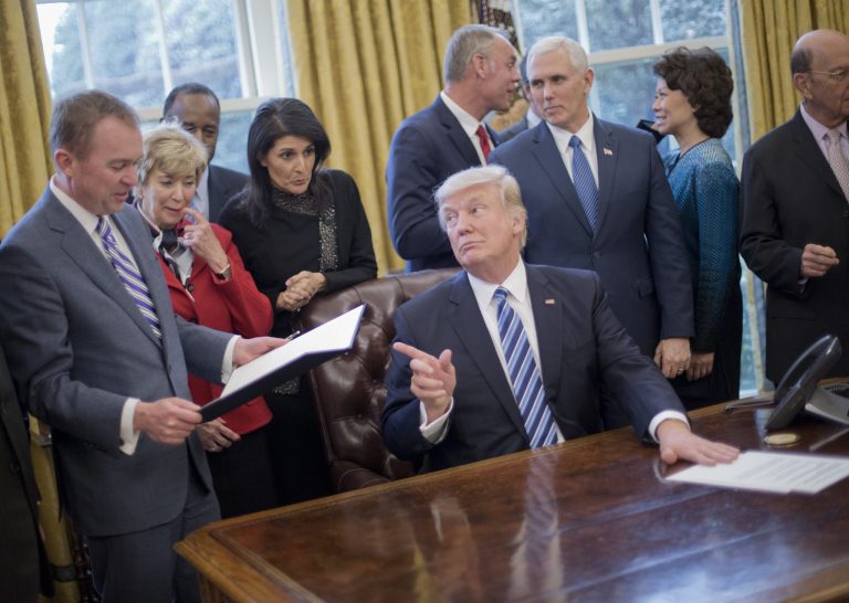 President Donald Trump looks over towards Budget Director Mick Mulvaney, left, after signing an executive order in the Oval Office of the White House in Washington, Monday, March 13, 2017. Trump signed "Comprehensive Plan for Reorganizing the Executive Branch."