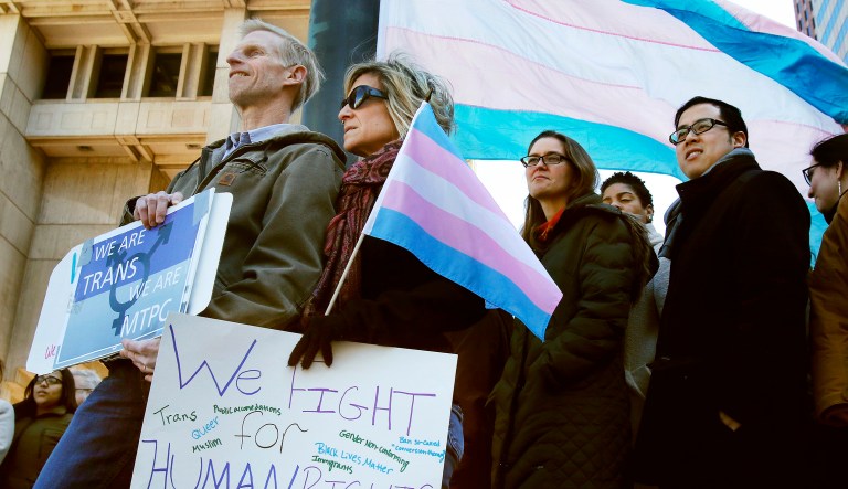 Eric and Evas Nelson, from Sandwich, Mass., and parents of a transgender child, wait for Boston Mayor Marty Walsh to arrive to raise a flag supporting the transgender community at City Hall, Thursday, March 30, 2017, in Boston. The flag-raising event was organized after the "Free Speech Bus," painted with the words "boys are boys" and "girls are girls," parked outside City Hall earlier in the day. 