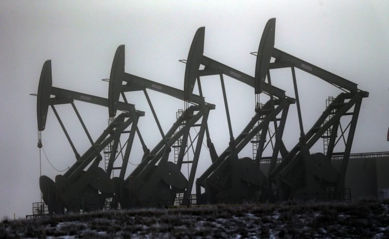 FILE - In this Dec. 19, 2014, file photo, oil pump jacks work in unison in Williston, N.D. In the heart of North Dakota's oil patch, there are hundreds of more jobs than takers. No longer is it easy to find a hotel room or a table at a restaurant. More than two years after the state's unprecedented oil bonanza fizzled, North Dakota is experiencing a sort of boomlet with an increase in drilling that has brought oil production back up to more than 1 million barrels daily. 