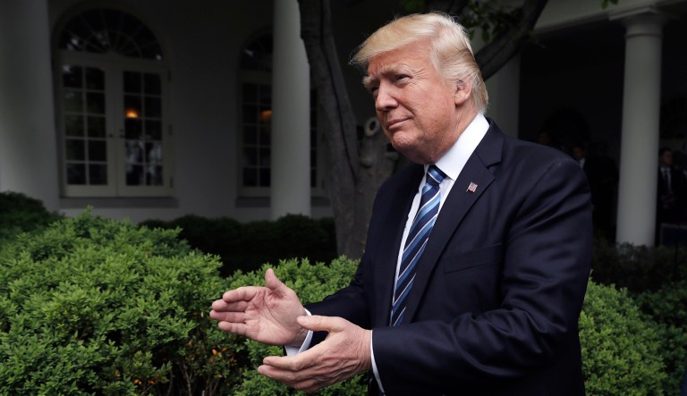 President Trump claps as he arrives in the Rose Garden of the White House in D.C.