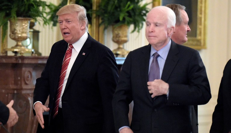President Donald Trump, second from left, reached out to shake hands with Sen. Todd Young, R-Ind., left, as he arrives for a meeting with Republican senators on health care in the East Room of the White House in Washington, Tuesday, June 27, 2017. Sen John McCain, R-Ariz., watches, third from right.