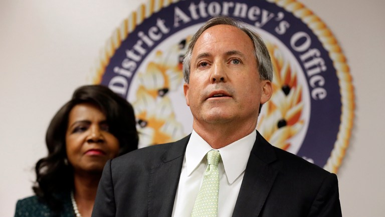 Texas Attorney General Ken Paxton, center, makes comments during a news conference.