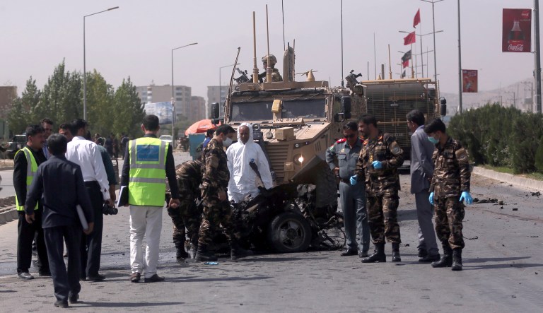 U.S. and Afghan security forces inspect the site of a suicide attack on NATO convoy in Kabul, Afghanistan, Sunday, Sept. 24, 2017. Afghanistan's Interior Ministry says a suicide car bomber has struck a convoy of international forces in the capital, wounding three civilians.