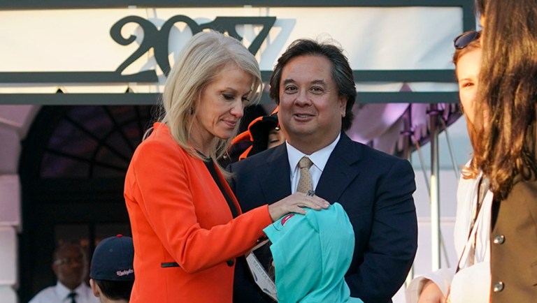 Then-Counselor to the President Kellyanne Conway, center, and her husband, George Conway, right, greet guests on the South Lawn of the White House.