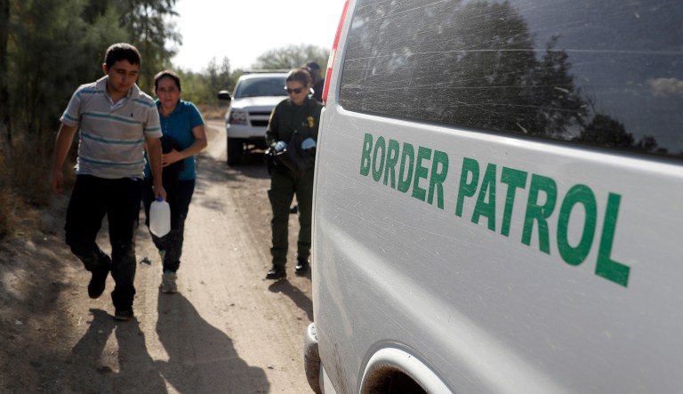 In this Aug. 11, 2017, photo, U.S. Customs and Border Patrol agents pick up immigrants suspected of crossing into the United States illegally along the Rio Grande near Granjeno, Texas.