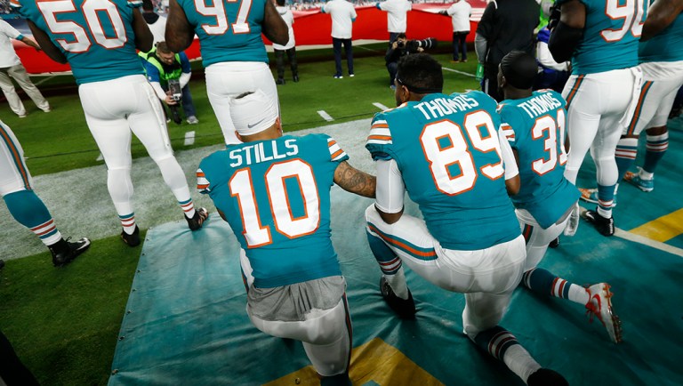 Miami Dolphins wide receiver Kenny Stills (10), tight end Julius Thomas (89) and strong safety Michael Thomas (31), kneel during the National Anthem.