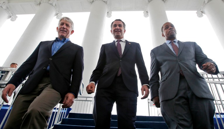Virginia Gov.-elect, Lt. Gov Ralph Northam, center, walks down the reviewing stand with Lt. Gov-elect, Justin Fairfax, right, and Attorney General Mark Herring, as they participate in a walk through for their Saturday Inauguration at the Capitol in Richmond, Va.