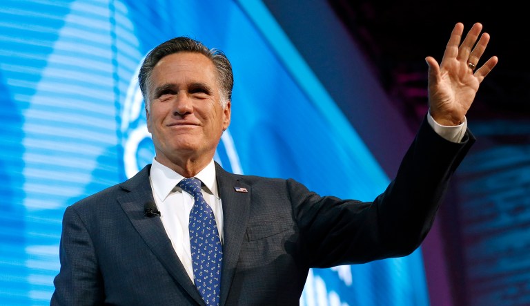 Former Republican presidential candidate Mitt Romney waves after speaking at a conference.