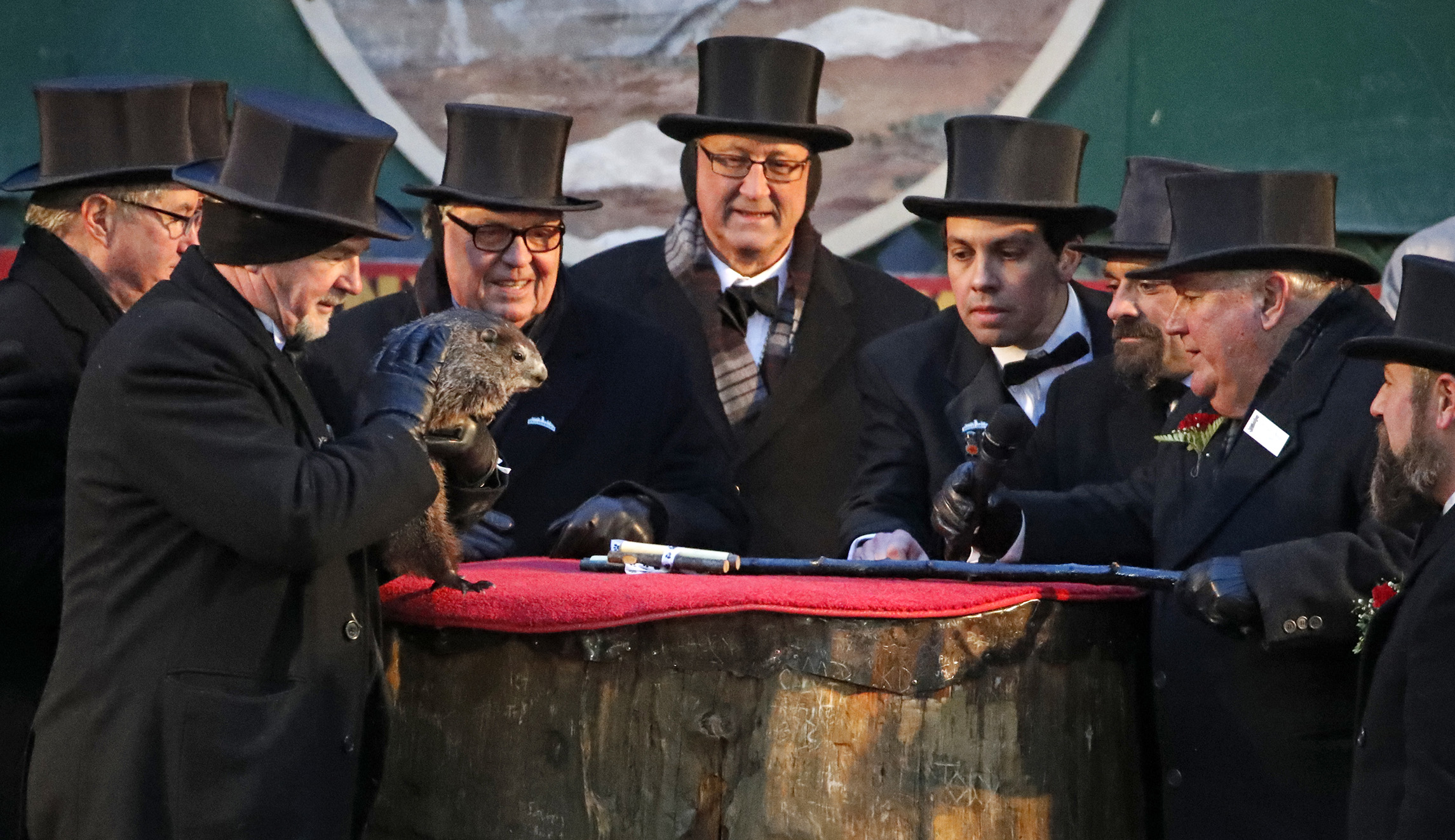 Groundhog Club co-handler John Griffiths, left, holds Punxsutawney Phil, the weather prognosticating groundhog, as President Bill Deeley, second from right, looks on during the 132nd celebration of Groundhog Day on Gobbler's Knob in Punxsutawney, Pa., on Saturday.