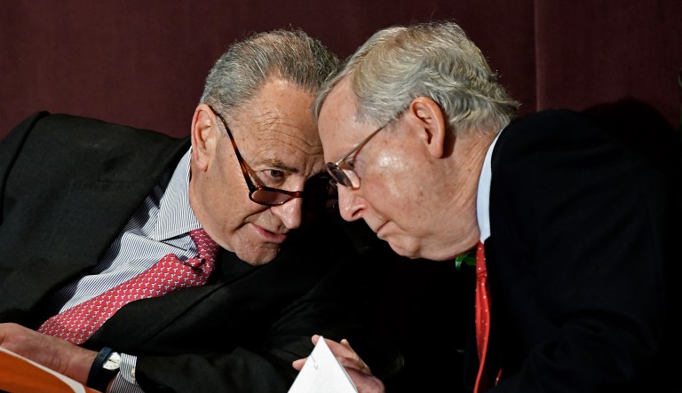 Senate Minority Leader Charles Schumer, D-N.Y., leans in to speak to Senate Majority Leader Mitch McConnell, R-Ky., before his speech at the McConnell Center's Distinguished Speaker Series Monday, Feb. 12, 2018, in Louisville, Ky.