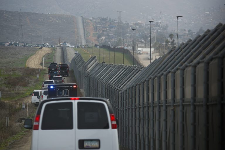 A motorcade carrying President Trump drives along the border before look at border wall prototypes in San Diego.
