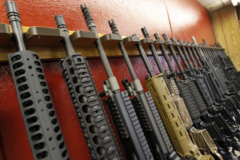 A row of different AR-15 style rifles are displayed for sale at the Firing-Line indoor range and gun shop in Aurora, Colo.