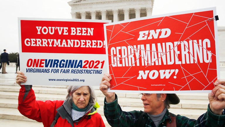 Sara Fitzgerald, left, and Michael Martin, both with the group One Virginia, protest gerrymandering in front of the Supreme Court.