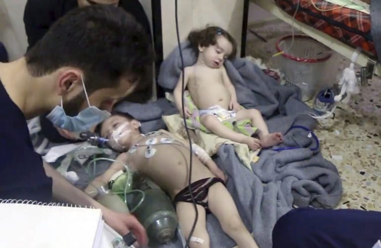 This image made from video released by the Syrian Civil Defense White Helmets, which has been authenticated based on its contents and other AP reporting, shows medical workers treating toddlers following an alleged poison gas attack in the opposition-held town of Douma, in eastern Ghouta, near Damascus, Syria, Sunday, April. 8, 2018. The Civil Defense said patients were having difficulty breathing and burning in their eyes. Syrian opposition activists and rescuers said Sunday that a poison gas attack on a rebel-held town near the capital. The Syrian government denied the allegations, which could not be independently verified.