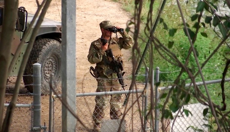 A National Guard troop watches over Rio Grande River on the border in Roma, Texas.