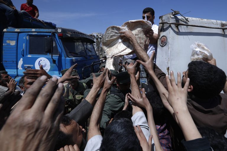 Syrian authorities distribute bread, vegetables and pasta to Douma residents, in the town of Douma, the site of a suspected chemical weapons attack, near Damascus, Syria, Monday, April 16, 2018. Two days after Syrian troops declared Douma, near the capital, Damascus, liberated from rebel fighters and 10 days since a suspected chemical attack, a tour on Monday revealed widespread destruction and traumatized residents who recalled months spent cowering in crowded underground shelters infested with lice, with barely any food or water.
