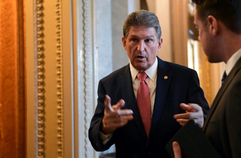 FILE - In this Jan. 22, 2018, file photo, Sen. Joe Manchin, D-W.Va., talks with a staffer on Capitol Hill in Washington, after passage of a procedural vote aimed at reopening the government. Former coal executive Don Blankenship went from prison to politics after serving a one-year sentence related to the deadliest U.S. mine disaster in four decades. His quest: To take down the man he blames for fueling public distrust of him, Democratic Manchin of West Virginia.