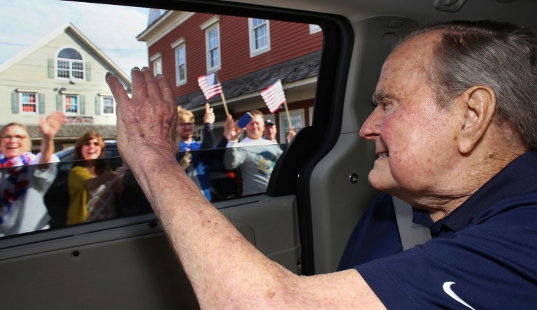 In this Sunday, May 20, 2018 photo provided by the office of former President George H.W. Bush, the former president waves to supporters as his motorcade arrives in Kennebunkport, Maine. A Bush spokesman said the nation's 41st president was eager to get to Maine after enduring his wife's death and then falling ill with a blood infection that landed him in the hospital.