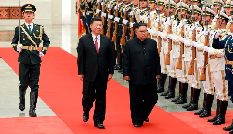 In this photo provided on June 20, 2018, by the North Korean government, Chinese President Xi Jinping, center left, and North Korean leader Kim Jong Un, center right, inspect the honor guard at the Great Hall of the People in Beijing, China. Korean language watermark on image as provided by source reads, "KCNA," which is the abbreviation for Korean Central News Agency.