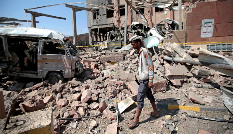 A man inspects rubble after a Saudi-led coalition airstrike in Sanaa, Yemen.