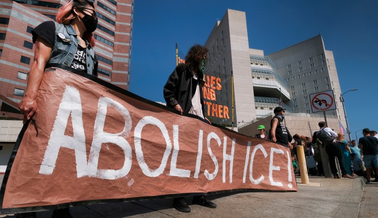 Protesters display a sign that reads "Abolish ICE" during a rally in front of the Immigration and Customs Enforcement facility in downtown Los Angeles on Monday, July 2, 2018. Protesters who were blocking the entrance to an Immigration and Customs Enforcement facility in downtown Los Angeles have been led away in handcuffs. A group of 17 protesters sat down in the street, blocking the entrance to the facility Monday morning. The protesters, including faith and community leaders, locked arms and chanted, "Shut down ICE!"