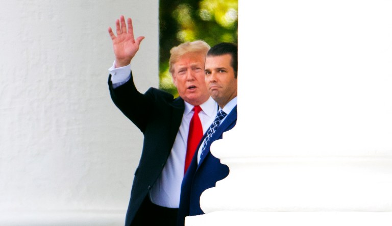 President Trump with his son Donald Trump Jr., waves from the North Portico as he leaves the White House. 