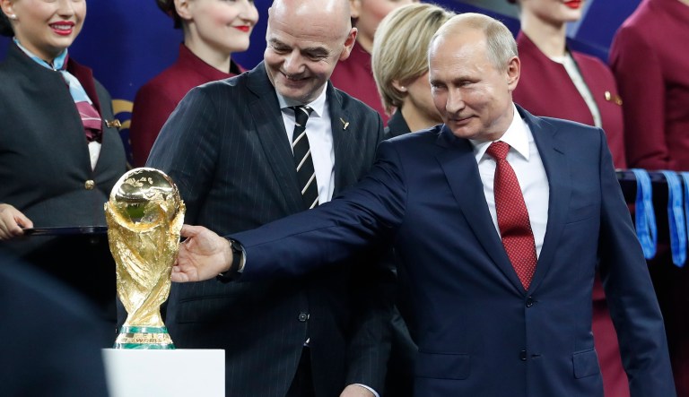 Russian President Vladimir Putin touches the World Cup trophy as FIFA President Gianni Infantino stands beside him, at the end of the final match between France and Croatia at the 2018 soccer World Cup in the Luzhniki Stadium in Moscow, Russia, Sunday, July 15, 2018. France won 4-2.