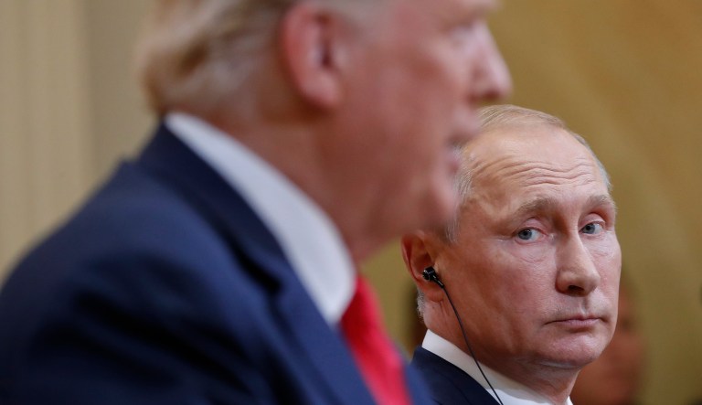 Russian President Vladimir Putin looks over toward President Trump as Trump speaks during a joint news conference at the Presidential Palace in Helsinki, Finland, on July 16, 2018.