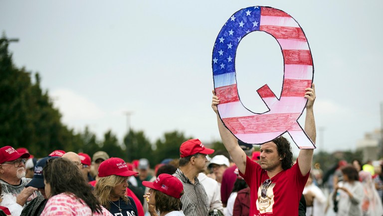 David Reinert holding a Q sign waits in line with others to enter a campaign rally with President Trump and Senate candidate Rep. Lou Barletta, R-Pa., Thursday, Aug. 2, 2018, in Wilkes-Barre, Pa. 
