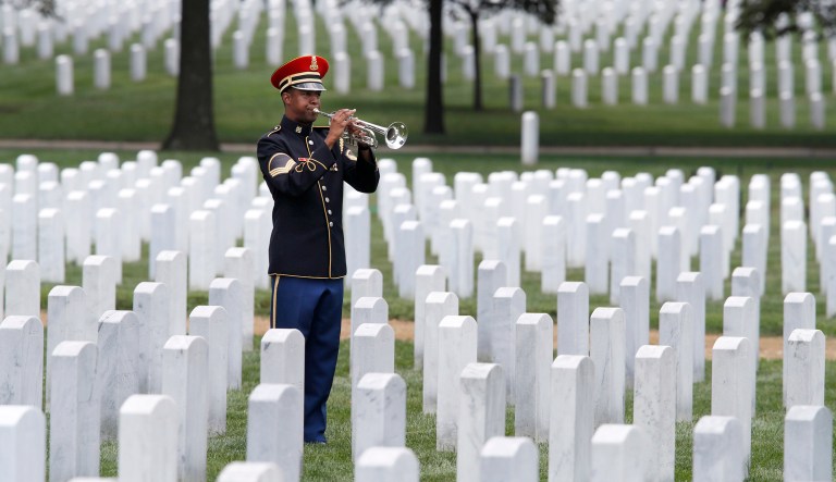A soldier with the 3rd Infantry Regiment, also known as the Old Guard, plays taps during the burial service of retired Army Col. Roger Brown, of Arlington, Va., at Arlington National Cemetery, in Arlington, Va., Monday, Aug. 6, 2018.